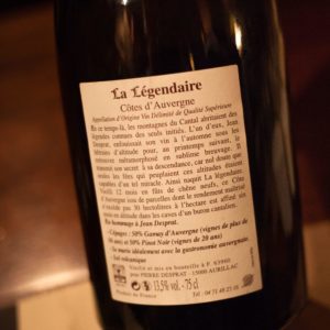 Contre étiquette d'une bouteille de vin détaillant l'origine, les cépages, les caractéristiques du terroir et des conseils d'accords, illustrant l'importance de lire à la fois l'étiquette principale et la contre étiquette.