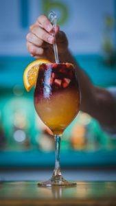 Image d'un cocktail rouge et orange avec des morceaux de fruits